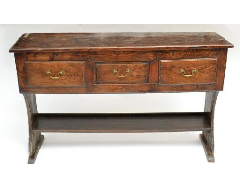 A late 18th or early 19th century West Somerset elm dresser with shaped planked ends supporting a central dummy drawer flanke