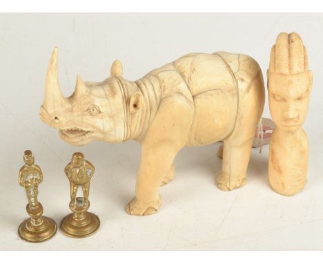 An African ivory carving of a rhinoceros, length 14.5cm, together with a pair of Dickensian brass pipe tampers and one other 
