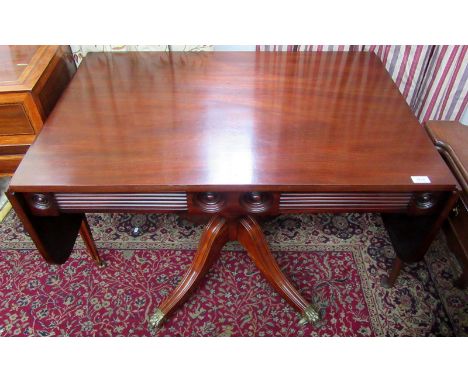 A Regency mahogany sofa table with moulded and roundel decorated frieze fitted a pair of drawers on vase pedestal with quadru