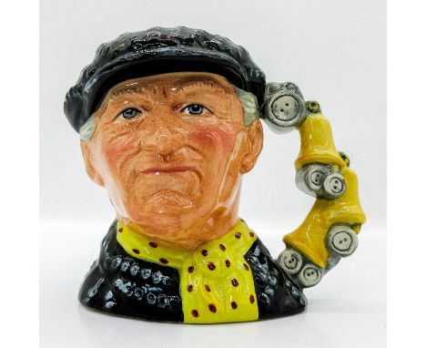 Black cap and jacket with silver buttons; yellow scarf with red polka dots.The Pearly King is the head spokesman for the stre