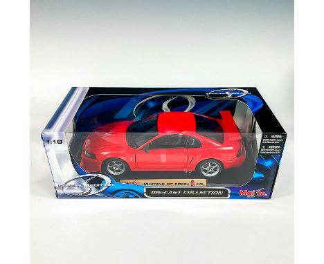 A factory sealed, replica die cast model Mustang Cobra in a red exterior. With moveable parts. This item has its original box