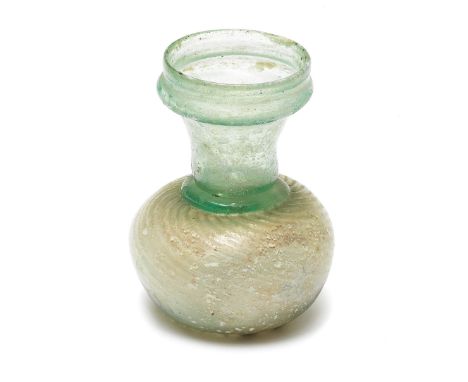  A Roman green glass sprinkler flask  Circa 3rd-4th Century A.D. The vertical rounded rim and tooled flange on a short cylind