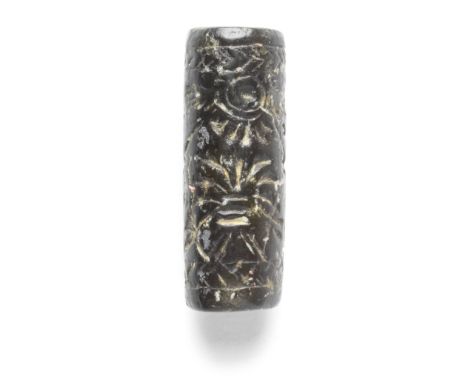  A Neo-Assyrian serpentine cylinder seal Circa 9th-7th Century B.C. Depicting a winged disc over a tree, flanked by men holdi