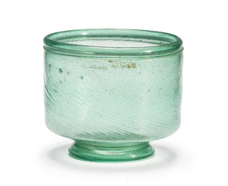  A large Late Roman bluish-green glass bowl Rhineland, circa 4th-5th Century A.D.The deep footed bowl, straight-sided with wr