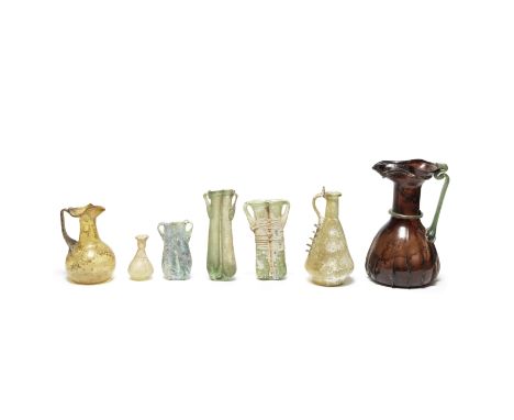  Seven Roman glass vessels       1st-5th Century A.D.Including a large and unusual aubergine glass jug, with pinched vertical