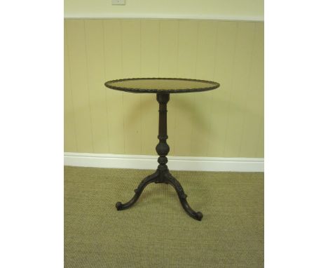 A Georgian style mahogany Tripod Table with carved edge, on turned baluster fluted column, husk pendant decoration to the tri