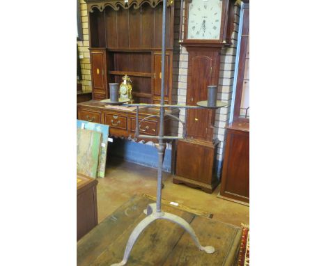An antique cast iron Candlestick on tripod base with central pricket, 52in H