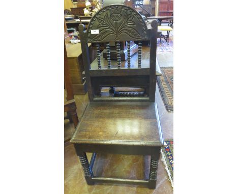 A 17th Century oak Side Chair with thistle carved top rail, spindle frieze, solid seat on bobbin turned and square legs