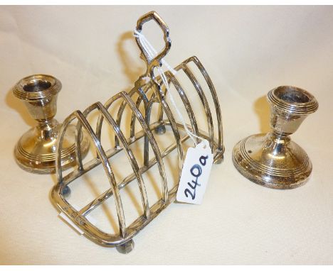 Sterling silver toast rack and a pair of silver weighted candlesticks. Toast rack hallmarked for London 1894 Henry Wilkinson 
