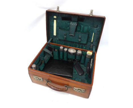 An Edwardian  brown leather vanity travel case with green silk fitted interior, by Walker and Hall containing glass and silve
