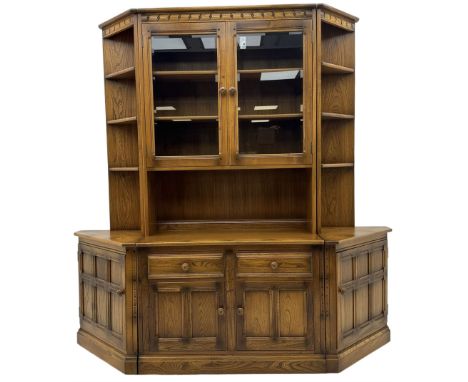 Ercol - elm three sectional wall cabinet, the central unit with raised display cabinet enclosed by bevel glazed doors, fitted