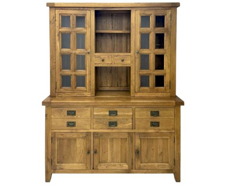 Oak dresser, upper section with twin glazed cupboard doors and central shelving with two trinket drawers, lower section fitte