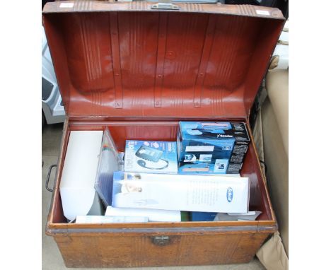 A tin trunk containing new and used items including a back massage cushion, Walkman, etc
