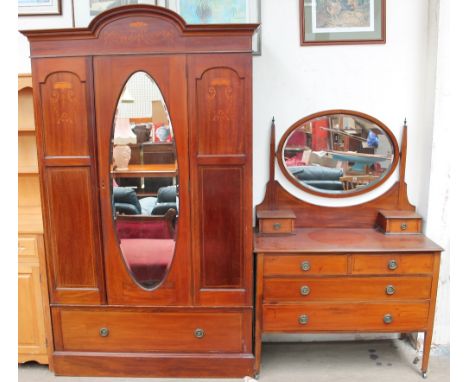 An Edwardian mahogany three-piece bedroom suite comprising a wardrobe, dressing table and matching washstand