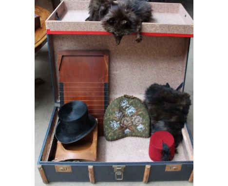 A wooden bound trunk, together with a fur stole, fur muff, a  beadwork tea cosy, a top hat, shove halfpenny board and fez hat
