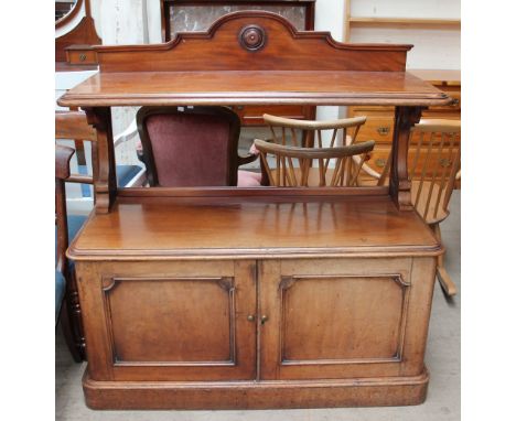 A 19th century mahogany buffet with a shaped back, rectangular rounded top shelf, the base with two cupboards on a plinth