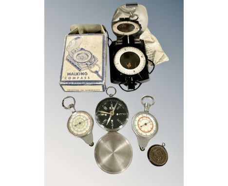 A walking compass in box together with four other compasses 