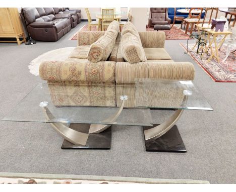 A contemporary glass coffee table with decorative shaped supports, further matching lamp table  