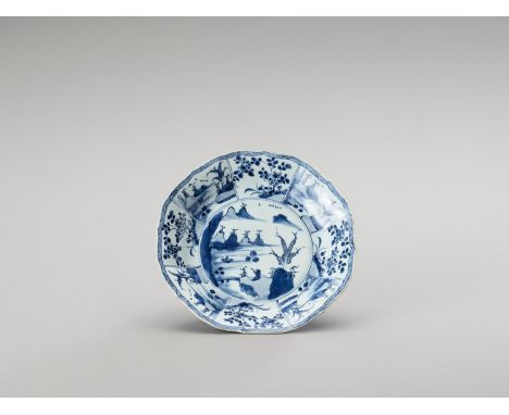   A LOBED AND DEEP BLUE AND WHITE PORCELAIN PLATE  China, Kangxi period (1662-1722). Painted in underglaze blue on the show s