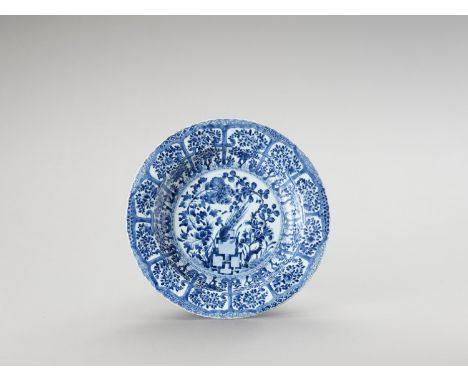   A LARGE ‘FLORAL’ BLUE AND WHITE PORCELAIN PLATE  China, Kangxi period (1662-1722). Painted in underglaze blue, the show sid