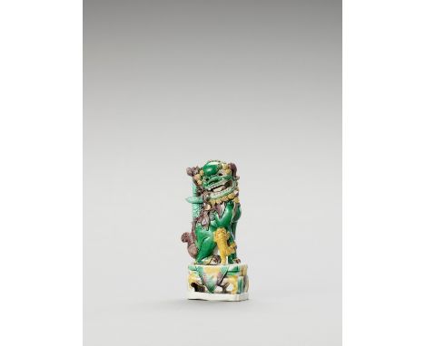   A FAMILLE VERTE ‘BUDDHIST LION’ PORCELAIN STICK HOLDER  China, Kangxi period (1662-1722). The lion is modelled seating on a