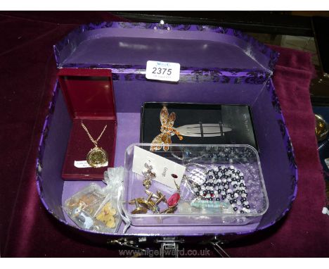 A quantity of costume jewellery including enamel badges, cuff links, dragonfly bookmark etc in purple case.