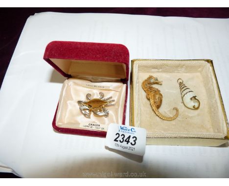 A gold plated crab star sign brooch, small shell shaped pendant and a tiny Seahorse skeleton.
