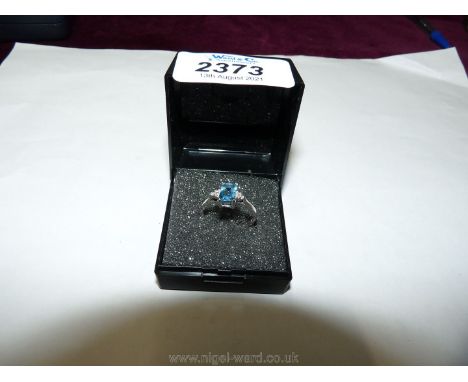 A 9ct white gold ring set with pale blue and tiny white stones.