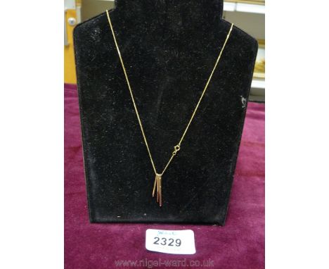 A 9ct gold chain with three needle like pendants.