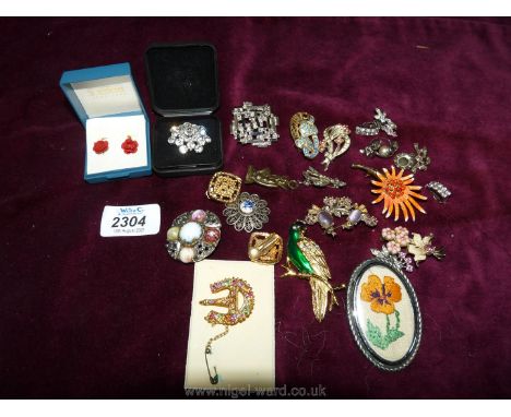 A small quantity of costume brooches including a pink and faux pearl starburst brooch, pair of marcasite clip-on earrings etc
