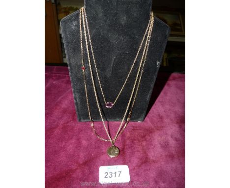 Three yellow metal Avon necklaces, one with rolled gold locket and two other with red and mauve stones.