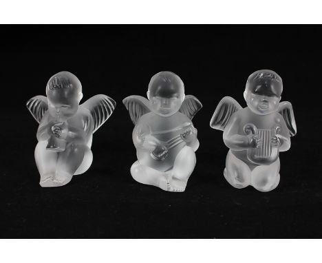 A set of three Lalique cherub musicians, one playing a horn, another a harp, and the third a lute, all with etched Lalique, F