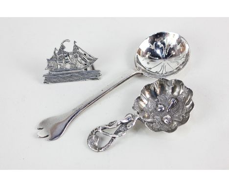 A Victorian silver caddy spoon with embossed leaf and fruiting vine form (marks obscured), together with a silver sifter spoo