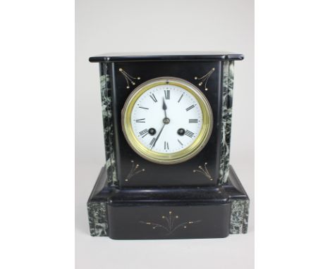 A Victorian black slate mantel clock with green marble trim, the dial with Roman numerals, the French movement striking on a 