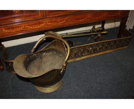 A brass coal scuttle, together with a pierced brass fire fender, coal shovel, pair of fire dogs, and other fire tools