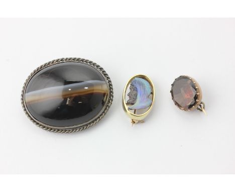 An opal doublet brooch carved with the profile of an Arab, a banded agate brooch, and a foil backed gem stone brooch