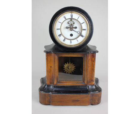 A 19th century mantel clock, the dial with visible escapement and Roman numerals, the Sun King pendulum behind glass, in ebon