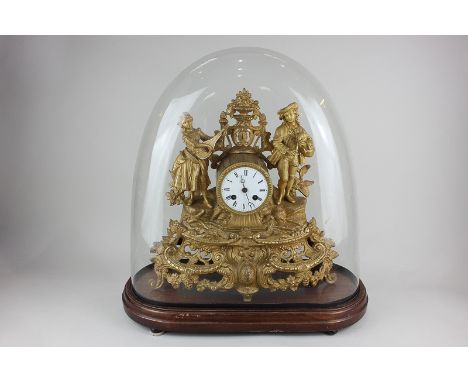A French gilt metal figural mantel clock decorated with two musicians, the dial with Roman numerals, on wooden base with glas