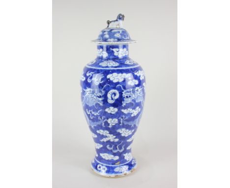 A Chinese pottery blue and white baluster vase and cover depicting dragons chasing the flaming pearl, the cover with temple d