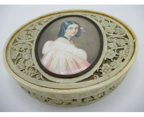 A 19th century ivory box of oval form, the pierced and carved lid inset with the head and shoulder portrait of a girl indisti