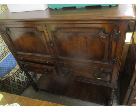 A reproduction oak side cabinet having two cupboard doors above two brush slides, two drawers and shelf below 49 1/2 H x 48 3