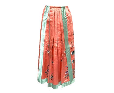 An early to mid 20th century Chinese silk wrap skirt, adjustable waist, embroidered with lotus blossoms and waves on a coral 