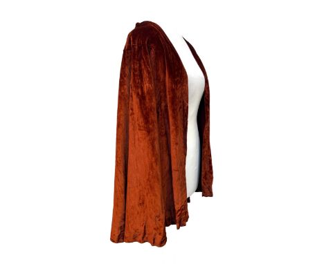 A burnt orange velvet cape by Bourne &amp; Hollingsworth London, W1, with hook and eye closure, silk crepe lining, bow back d