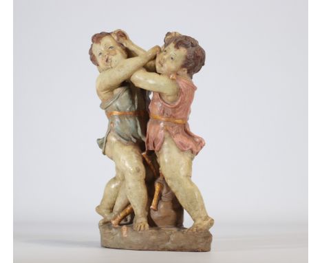 Polychrome terracotta sculpture in the shape of two boys called "la dispute". The two young boys are dressed in red and blue.