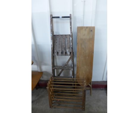 A step ladder, ironing board and clothes airer