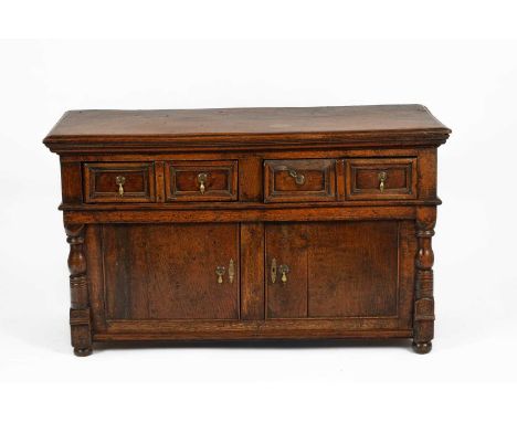 A 17th Century style oak sideboard the moulded top over four drawers with moulded panels and brass drop handles, the pair of 