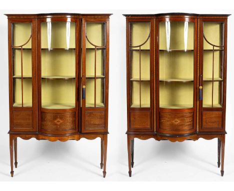 A pair of Edwardian inlaid display cabinets with bowed central sections, on tapering supports and spade feet, each: 114cm wid