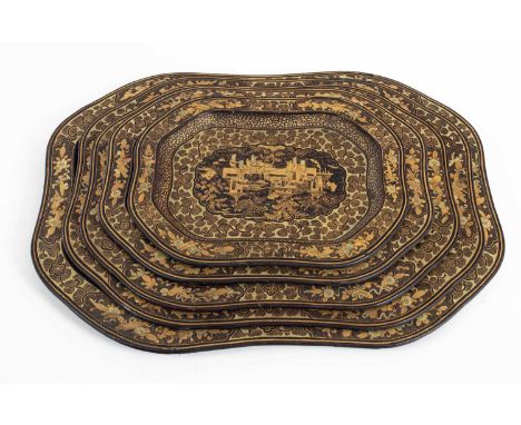 A nest of five Chinese export black lacquer trays 19th Century, with gilt painted decoration of figures before buildings in a