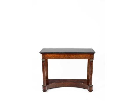 An Empire mahogany console table, the black marble top above a frieze drawer on column front legs to a platform base with con