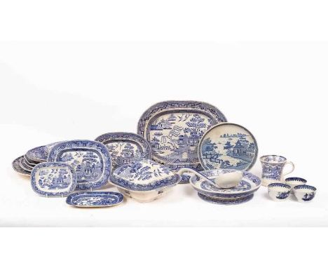 A group of English blue and white pottery, mostly Willow pattern, comprising nine platters in various sizes, a mug, ladle, tu
